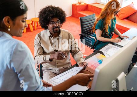 Piccolo gruppo multietnico di imprenditori che si incontrano in un ufficio aziendale di coworking - giovani colleghi che lavorano insieme in un creativo Foto Stock