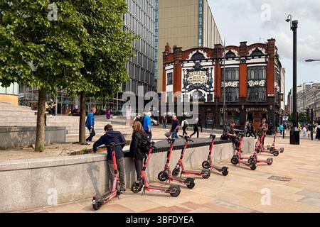 E-scooter parcheggiati di fronte alla stazione di Lime Street e al Crown Hotel nel centro di Liverpool Foto Stock