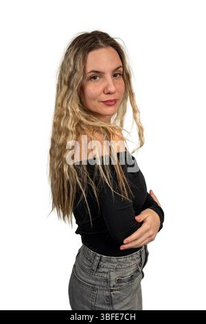 Giovane donna che posa con fiducia su un semplice sfondo bianco Foto Stock