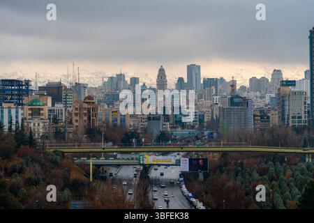 Teheran, Iran - 12 novembre 2023: Paesaggio urbano di Teheran con fitti edifici e montagne innevate sullo sfondo Foto Stock