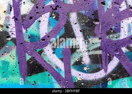 pareti in cemento dipinte a mano nei colori viola e blu. spruzzare la vernice. sfondo astratto. Foto Stock