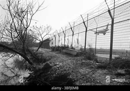 All'inizio degli anni '2010, China Airport Perimeter Fence con Landing Airplane e Rural Canal Foto Stock