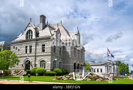 Architettura in pietra in stile tardo vittoriano del New Hampshire legislative Office Building a Concord, catturata sotto spettacolari nuvole e vibranti paesaggi primaverili Foto Stock