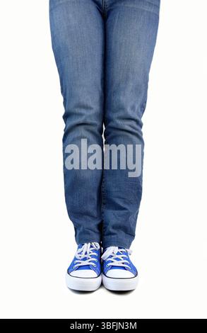 Foto corta di un giovane in piedi isolato su sfondo bianco con scarpe in tela Foto Stock