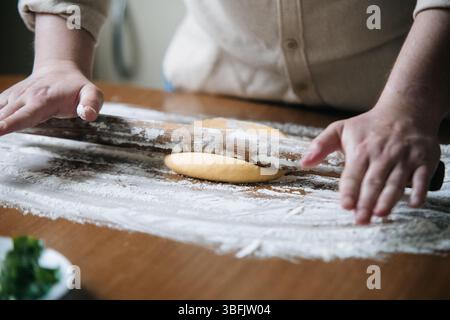 Un uomo sta stendendo la pasta Foto Stock