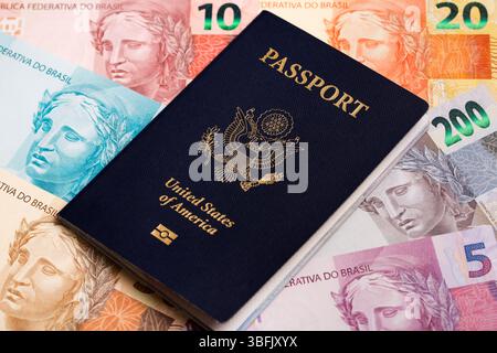 Passaporto americano su un denaro brasiliano - reale Foto Stock