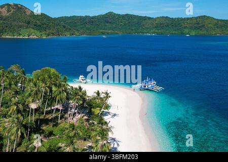 Spettacolare vista aerea della vibrante barriera corallina, delle acque turchesi e di una barra di sabbia bianca al largo della remota isola di Mamón a Siargao, Filippine. Foto Stock