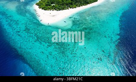 Spettacolare vista aerea della vibrante barriera corallina, delle acque turchesi e di una barra di sabbia bianca al largo della remota isola di Mantigue nelle Filippine. Foto Stock