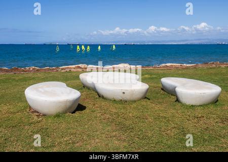 Moderne panchine bianche in cemento su erba verde che si affacciano sul mare di Haifa. L'argine prende il nome da Khulda Gurevich, Foto Stock
