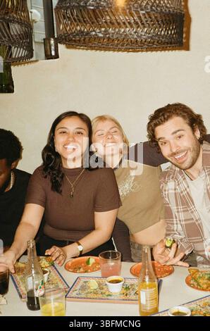 Ritratto di diversi amici maschi e femmine che trascorrono del tempo libero al ristorante Foto Stock