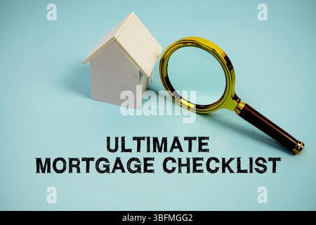 Testo Ultimate Mortgage Checklist con White Model House e lente d'ingrandimento su sfondo blu Foto Stock