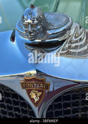 Albufeira, Portogallo - 24 maggio 2025: L'ornamento del cofano del tappo del radiatore Pontiac d'epoca viene mostrato da vicino su un'auto in una vista ravvicinata durante il giorno. Foto Stock