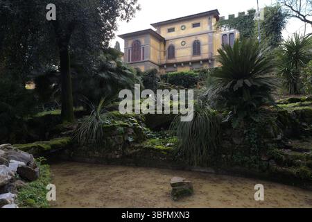 Vista del Museo Stibbert dal giardino, con la facciata neogotica, il paesaggio, gli alberi e i sentieri in pietra, Firenze, Italia Foto Stock