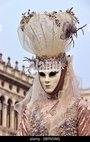 Maschera veneziana, ornata e misteriosa, risplende con accenti d'oro, piume e motivi intricati, evocando la grandiosità dei carnevali del vecchio mondo a Venezia. Foto Stock