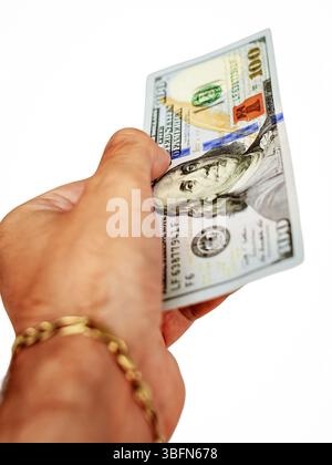 Un'immagine ravvicinata di una mano con una banconota da 100 dollari, che rappresenta transazioni finanziarie, scambi economici e il potere del contante nella finanza personale e aziendale. Fotografia verticale Foto Stock