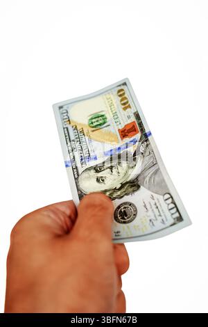 Un'immagine ravvicinata di una mano con una banconota da 100 dollari, che rappresenta transazioni finanziarie, scambi economici e il potere del contante nella finanza personale e aziendale. Fotografia verticale di scorta Foto Stock