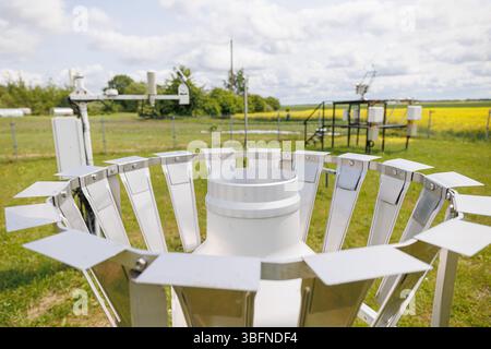Primo piano di un pluviometro in una stazione meteorologica utilizzata per misurare le precipitazioni in un campo rurale. Foto di alta qualità Foto Stock