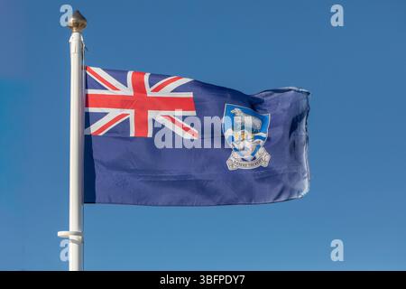 La bandiera delle Isole Falkland fluttua nella brezza della capitale, Stanley. Il motto è "desidero il diritto”. Foto Stock