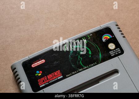 Primo piano della cartuccia per videogiochi "Alien 3" Super Nintendo, isolata su sfondo bianco chiaro. Solo per uso editoriale. Vista angolo superiore. Foto Stock
