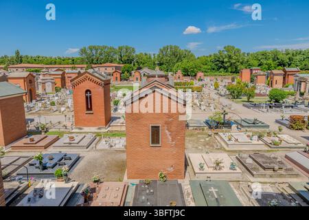 Ferrara, Italia - 17 maggio 2025: Con tombe, un grande muro di mattoni rossi e una piccola cappella, il cimitero monumentale della Certosa di Ferrara Foto Stock