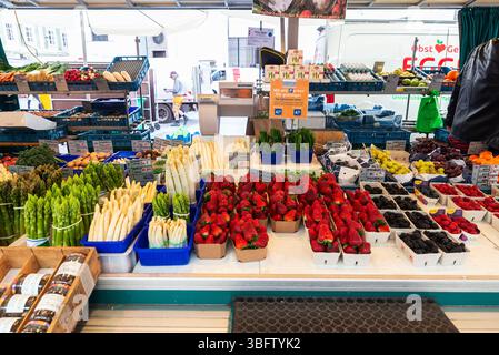 Salisburgo, Austria - 2 aprile 2025: Negozio di frutta e verdura con asparagi e fragole a Grunmarkt, mercato di Street food sull'Universitatsplatz a Sal Foto Stock