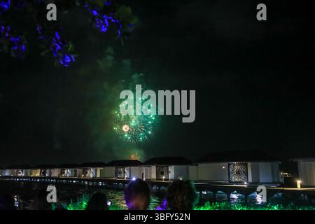 Fuochi d'artificio sopra le cabine sul mare per le celebrazioni di Capodanno presso il resort di vacanza Cinnamon Dhonveli, Malé, Maldive, Oceano Indiano Foto Stock