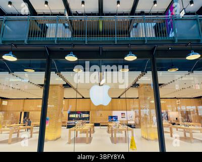 LONDRA, REGNO UNITO – 23 MARZO 2025: Vista esterna dell'Apple Store di Battersea con la sua iconica facciata in vetro e il logo illuminato. Foto Stock