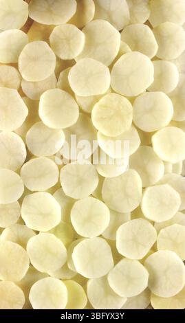 Patate a fette che riempiono la cornice creando uno sfondo alimentare Foto Stock
