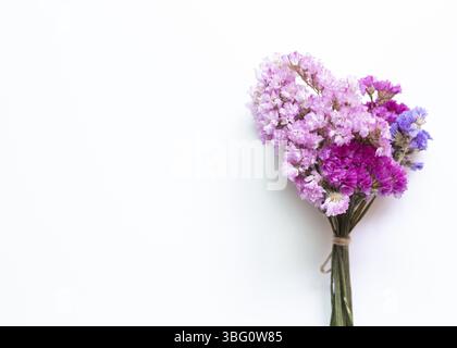 Rosa viola statice fiori bouquet su sfondo bianco. Composizione floreale, piatto, vista dall'alto Foto Stock