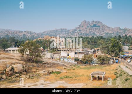 Montagne di pietra e palme, il paesaggio della città vecchia di Hampi, India, Asia Foto Stock