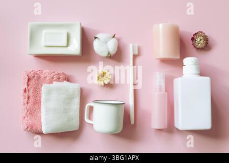 Prodotti per la cura del corpo su sfondo rosa, vari accessori per vasca idromassaggio, disposizione piatta, vista dall'alto Foto Stock