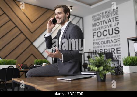 Ritratto di un avvocato di successo che parla al telefono in ufficio Foto Stock