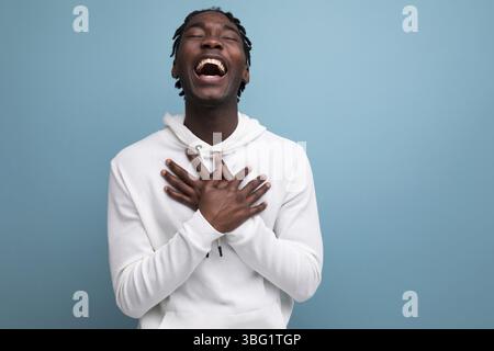 Gioioso vincitore africano anni '20 uomo con dreadlocks sullo sfondo e spazio per copiare Foto Stock