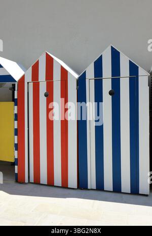 Colorate capanne sulla spiaggia a righe in una giornata di sole Foto Stock