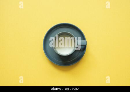 Tazza di latte isolato su fondo giallo. vista dall'alto, spazio copia, minimalismo Foto Stock