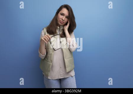 Stanca, giovane donna bruna, nella vita di tutti i giorni soffre di disagio quando indossa gli occhiali da vista Foto Stock