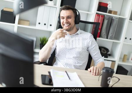 Un giovane uomo in pantaloni blu e una maglietta di luce. Un bel giovane con una stoppia sul suo viso. foto con profondità di campo Foto Stock
