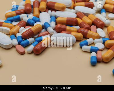 Pillola bianca con impronta MERCK posta su un mucchio di compresse e capsule colorate in una vista farmaceutica. Foto Stock