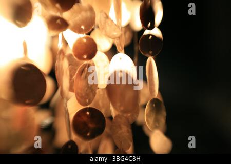 Primo piano di dischi pensili illuminati con una calda luce ambientale e una messa a fuoco morbida, per creare un'atmosfera accogliente, astratta ed elegante. Foto Stock
