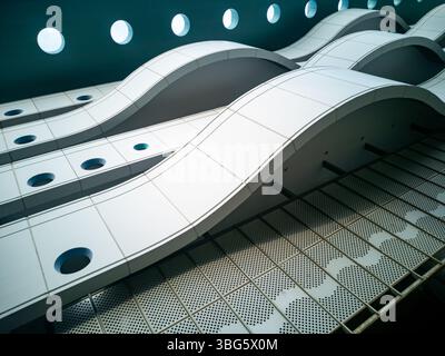 Questa immagine presenta un design architettonico innovativo caratterizzato da curve lisce e linee pulite, che creano uno spazio interno accattivante e moderno. Foto Stock