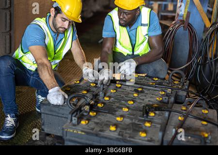 Ingegneri addetti alla manutenzione che stanno caricando la vecchia batteria, l'alimentazione del treno che utilizza la cabina del convoglio ferroviario Foto Stock