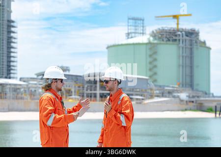 Lavoratori professionisti del settore petrolifero, ispezione di manutenzione di serbatoi di GNL di contenimento, ispettore del sito di gas onshore lavoro di squadra di sicurezza, IND petrolchimico nel settore petrolio e gas Foto Stock