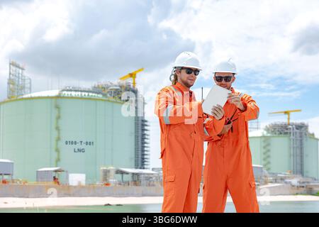Lavoratori professionisti del settore petrolifero, ispezione di manutenzione di serbatoi di GNL di contenimento, ispettore del sito di gas onshore lavoro di squadra di sicurezza, IND petrolchimico nel settore petrolio e gas Foto Stock