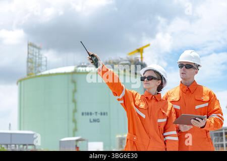 Lavoratori professionisti del settore petrolifero, ispezione di manutenzione di serbatoi di GNL di contenimento, ispettore del sito di gas onshore lavoro di squadra di sicurezza, IND petrolchimico nel settore petrolio e gas Foto Stock