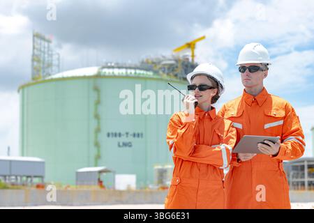 Lavoratori professionisti del settore petrolifero, ispezione di manutenzione di serbatoi di GNL di contenimento, ispettore del sito di gas onshore lavoro di squadra di sicurezza, IND petrolchimico nel settore petrolio e gas Foto Stock