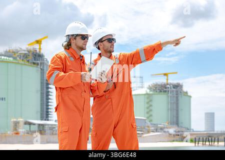Lavoratori professionisti del settore petrolifero, ispezione di manutenzione di serbatoi di GNL di contenimento, ispettore del sito di gas onshore lavoro di squadra di sicurezza, IND petrolchimico nel settore petrolio e gas Foto Stock