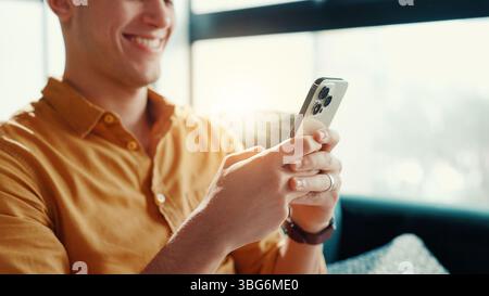 Giochi, videogiochi e uomo con smartphone, casa e intrattenimento per i gamer con tecnologia in salotto. Relax, giocatore e persona con app mobile per Foto Stock