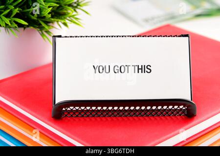 HAI scritto QUESTE parole su un biglietto da visita bianco in un supporto su una pila di notebook. Foto Stock