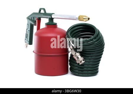 Vista dettagliata di un utensile ad aria compressa verde e rosso con tubo flessibile a spirale, ideale per applicazioni industriali e domestiche, posizionato isolato su cl Foto Stock