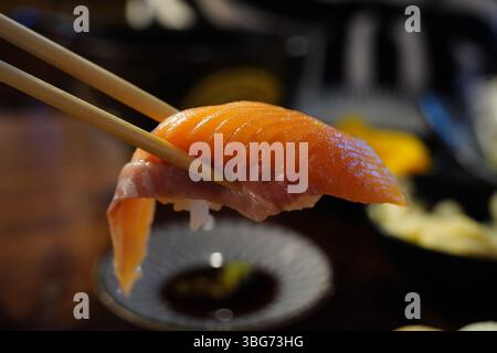 Sushi al salmone Nigiri con bastoncini Foto Stock